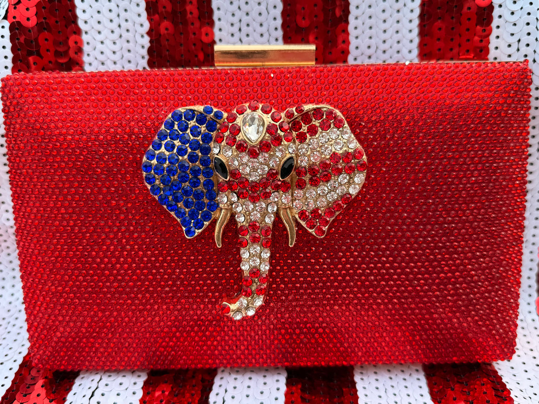 Stunning Red Crystal Clutch Handbag. Embellished with a beautiful red, white, & blue crystal elephant. Chain included for shoulder wear.